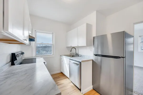 a kitchen with stainless steel appliances a refrigerator sink and cabinets