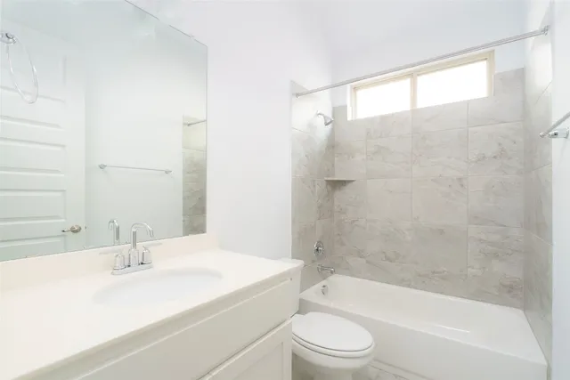 a bathroom with a bathtub shower sink vanity and toilet