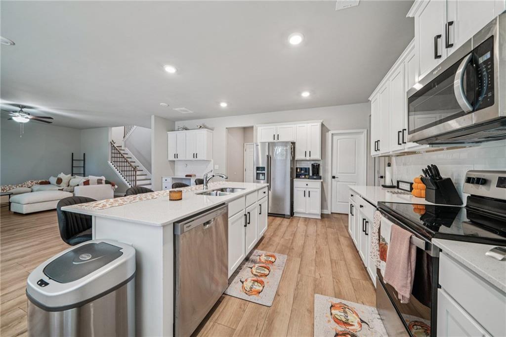 120 Cabin Way Hampton, GA 30228 - Photo 13 of 51 a large kitchen with stainless steel appliances kitchen island a large counter tops a sink a stove and cabinets