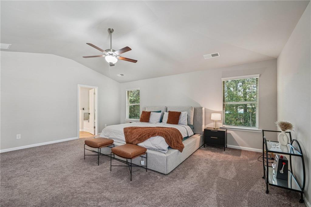120 Cabin Way Hampton, GA 30228 - Photo 30 of 51 a spacious bedroom with a bed and a chandelier