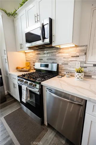 a kitchen with stainless steel appliances kitchen island granite countertop a sink and refrigerator