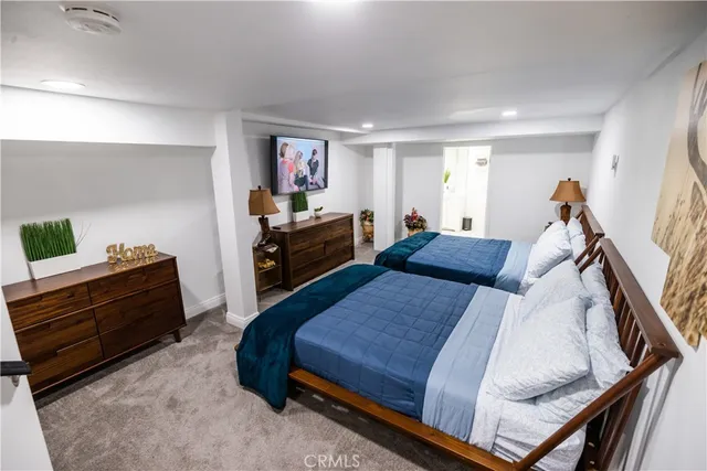 a bedroom with a bed a couch and a flat screen tv