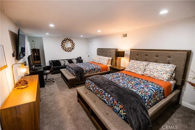 a bedroom with two bed and painting on the wall