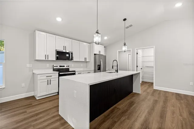 a kitchen with white cabinets and stainless steel appliances