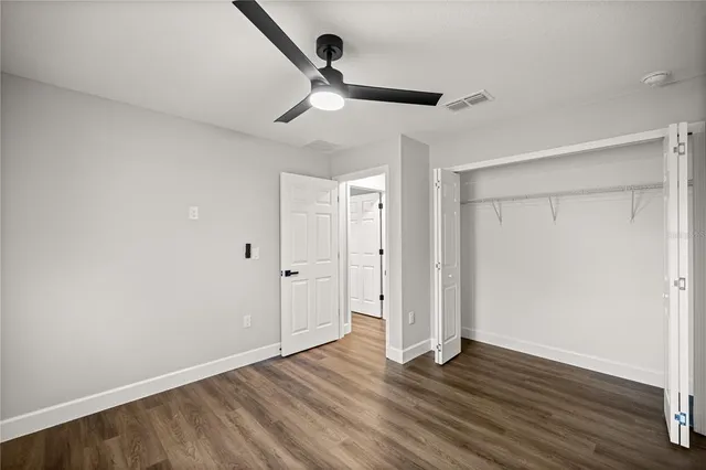 an empty room with window and ceiling fan