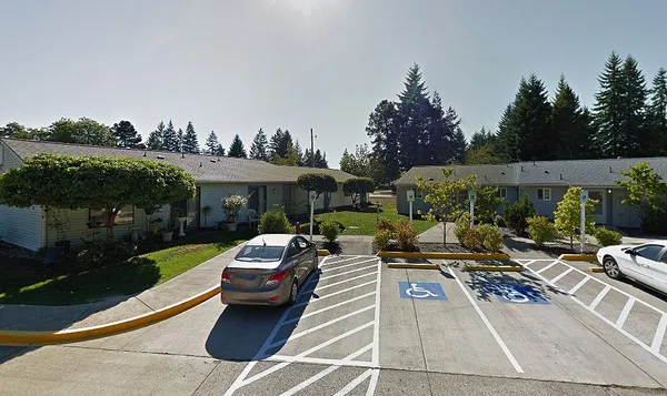 a view of a patio with couches table and chairs under an umbrella with a garden