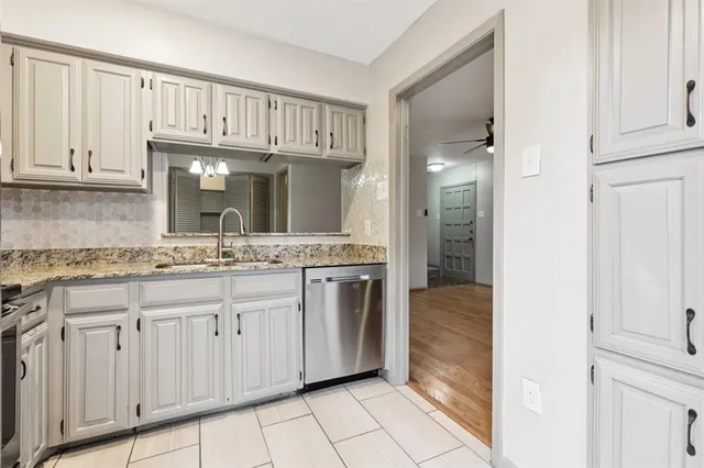 a en suite bathroom with a granite countertop sink and a mirror