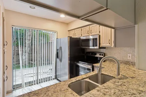 a kitchen with stainless steel appliances granite countertop a sink a stove and a refrigerator