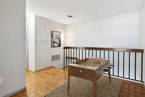 a view of a hallway with wooden floor and dining room