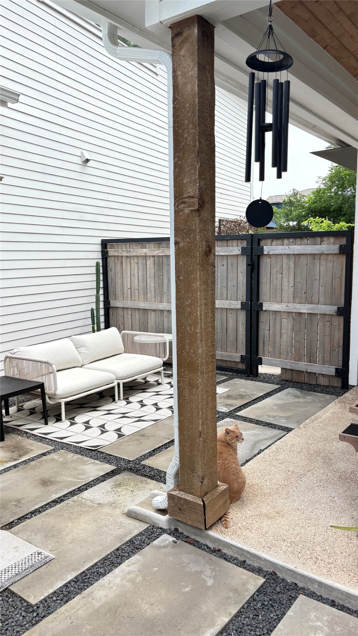 1816 Adina Street, Unit 2 Austin, TX 78721 - Photo 23 of 25 Outdoor patio featuring large square pavers with gravel infill, a wood-paneled privacy fence, and a modern white siding exterior