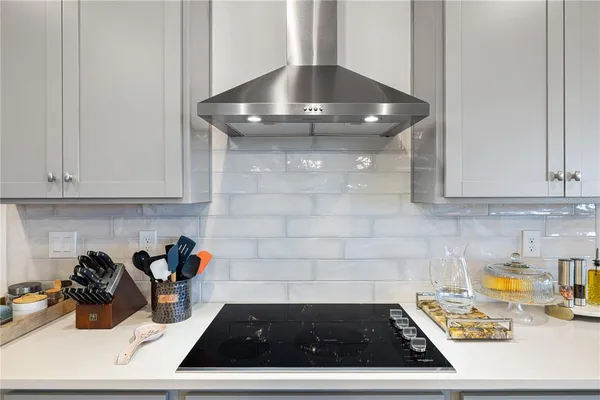 a kitchen with stainless steel appliances a table chairs refrigerator and sink