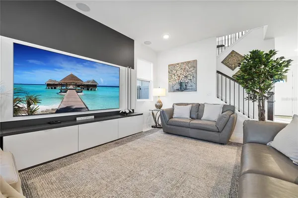 a living room with furniture kitchen area and a window