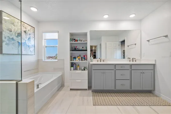 a spacious bathroom with a shower sink and mirror