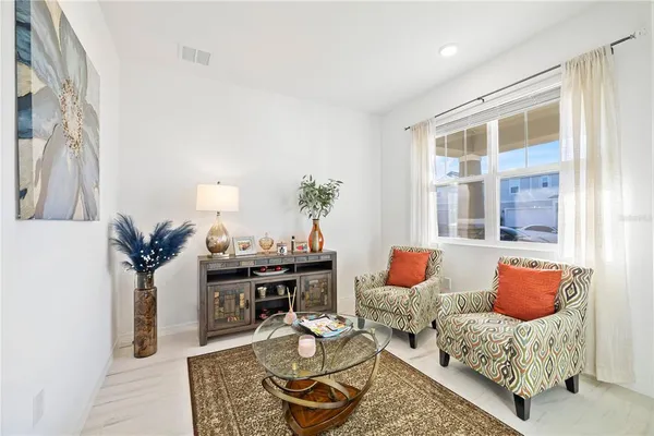a living room with furniture and wooden floor
