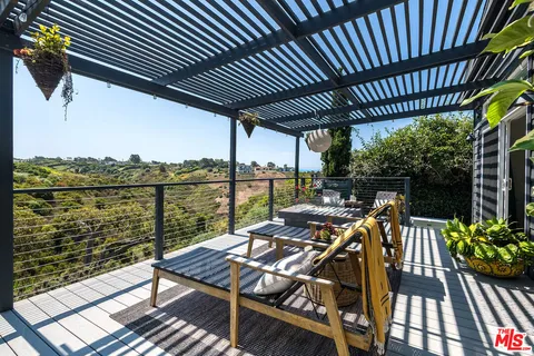 a view of a balcony with chairs and wooden floor