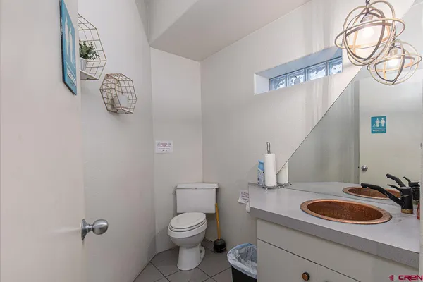 a bathroom with a toilet sink vanity granite and mirror