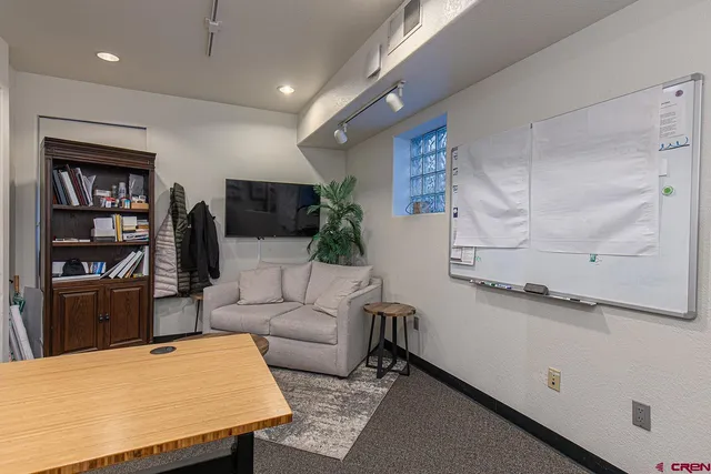 a living room with furniture a table and kitchen view
