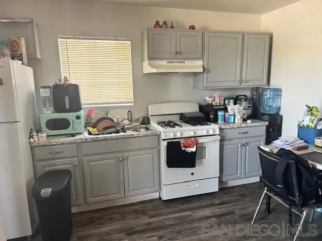 a kitchen with a stove a sink and white appliances