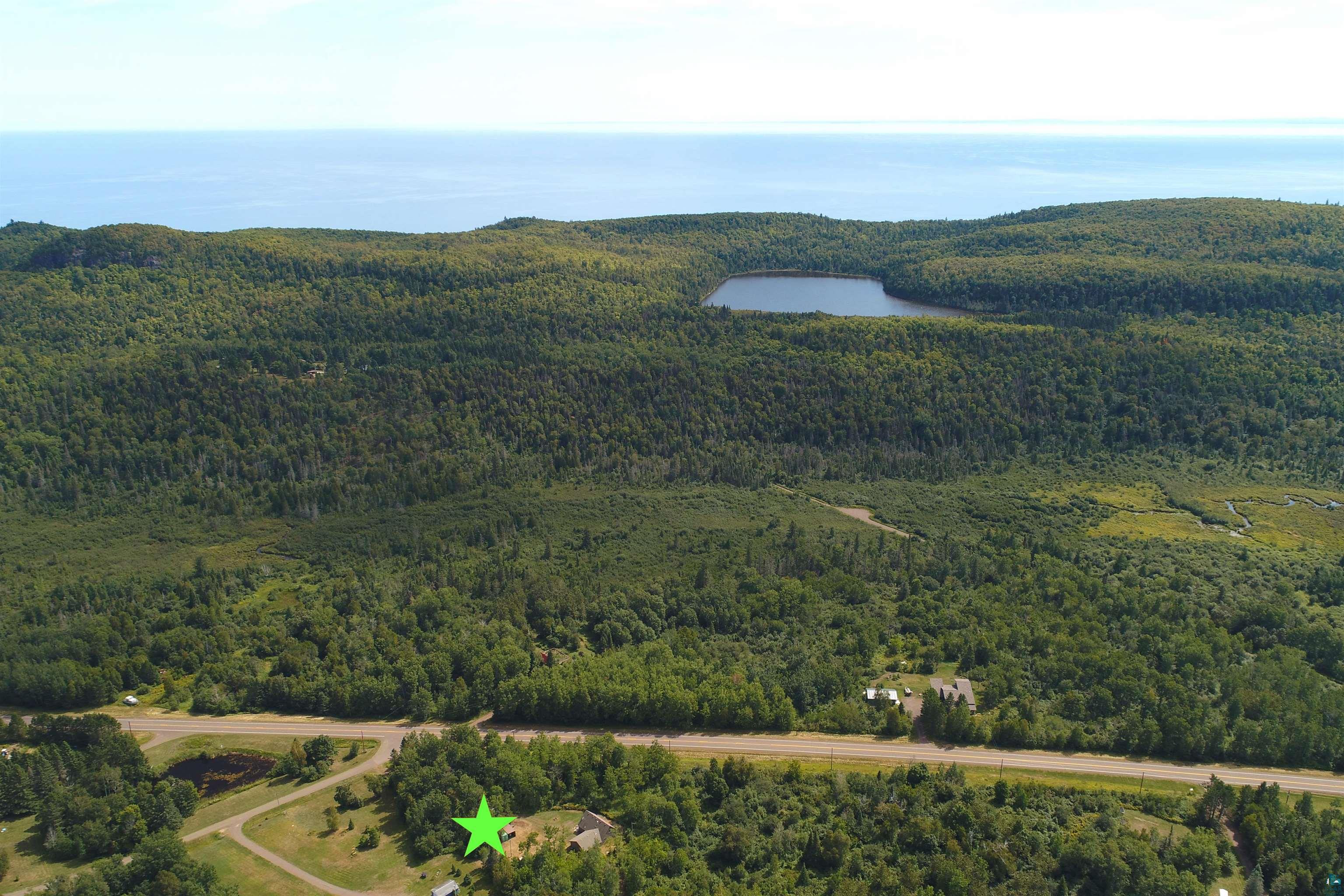6555 Roses Road Finland, MN 55603 - Photo 20 of 24 Aerial perspective showcasing expansive rural property encompassing dense forest coverage, open pastureland, and a natural pond nestled within the wooded landscape