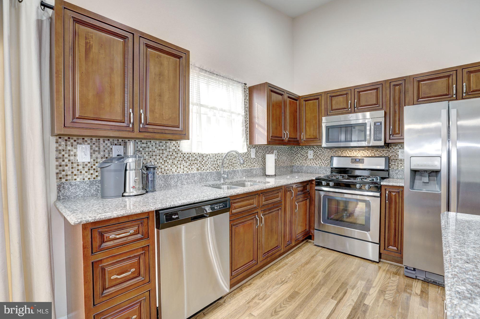 13108 Holdridge Road Silver Spring, MD 20906 - Photo 11 of 30 a kitchen with stainless steel appliances granite countertop a sink stove and refrigerator