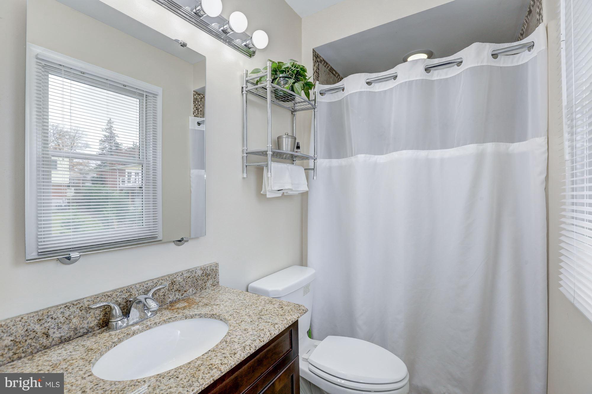13108 Holdridge Road Silver Spring, MD 20906 - Photo 13 of 30 a bathroom with a granite countertop sink toilet and mirror