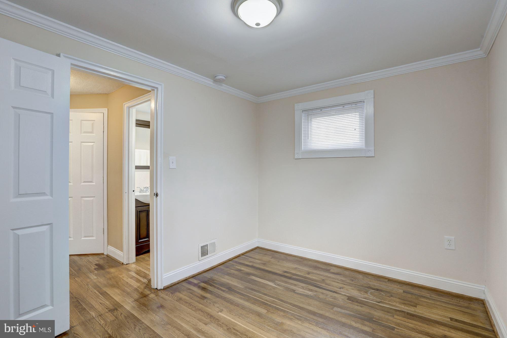 13108 Holdridge Road Silver Spring, MD 20906 - Photo 20 of 30 a view of an empty room with wooden floor and a window