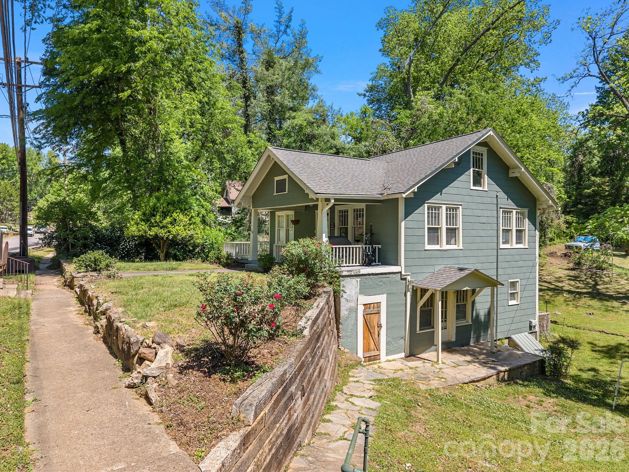 110 Grady Avenue Tryon, NC 28782 - Photo 3 of 41 a front view of a house with a yard garage and outdoor seating