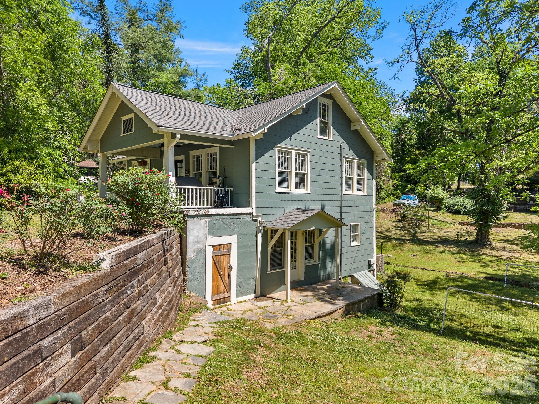 110 Grady Avenue Tryon, NC 28782 - Photo 37 of 41 a view of a house with a yard and lawn chairs under an umbrella
