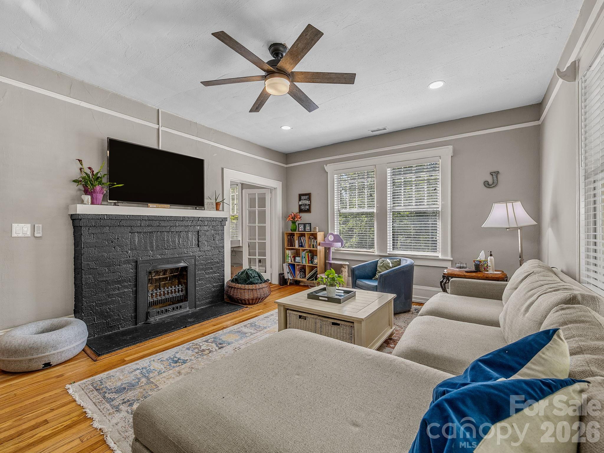 110 Grady Avenue Tryon, NC 28782 - Photo 8 of 41 a living room with furniture a fireplace and a flat screen tv
