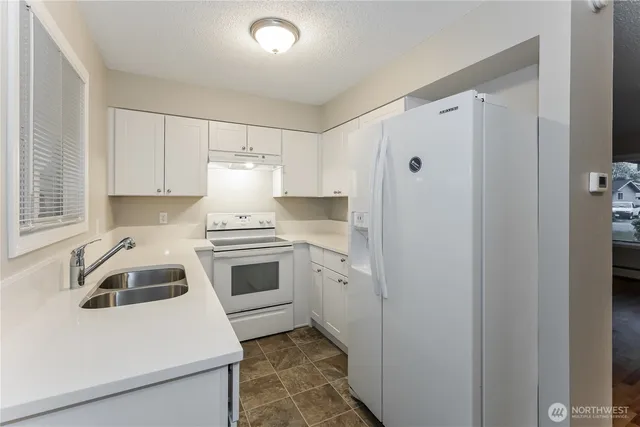 a kitchen with a sink and white cabinets