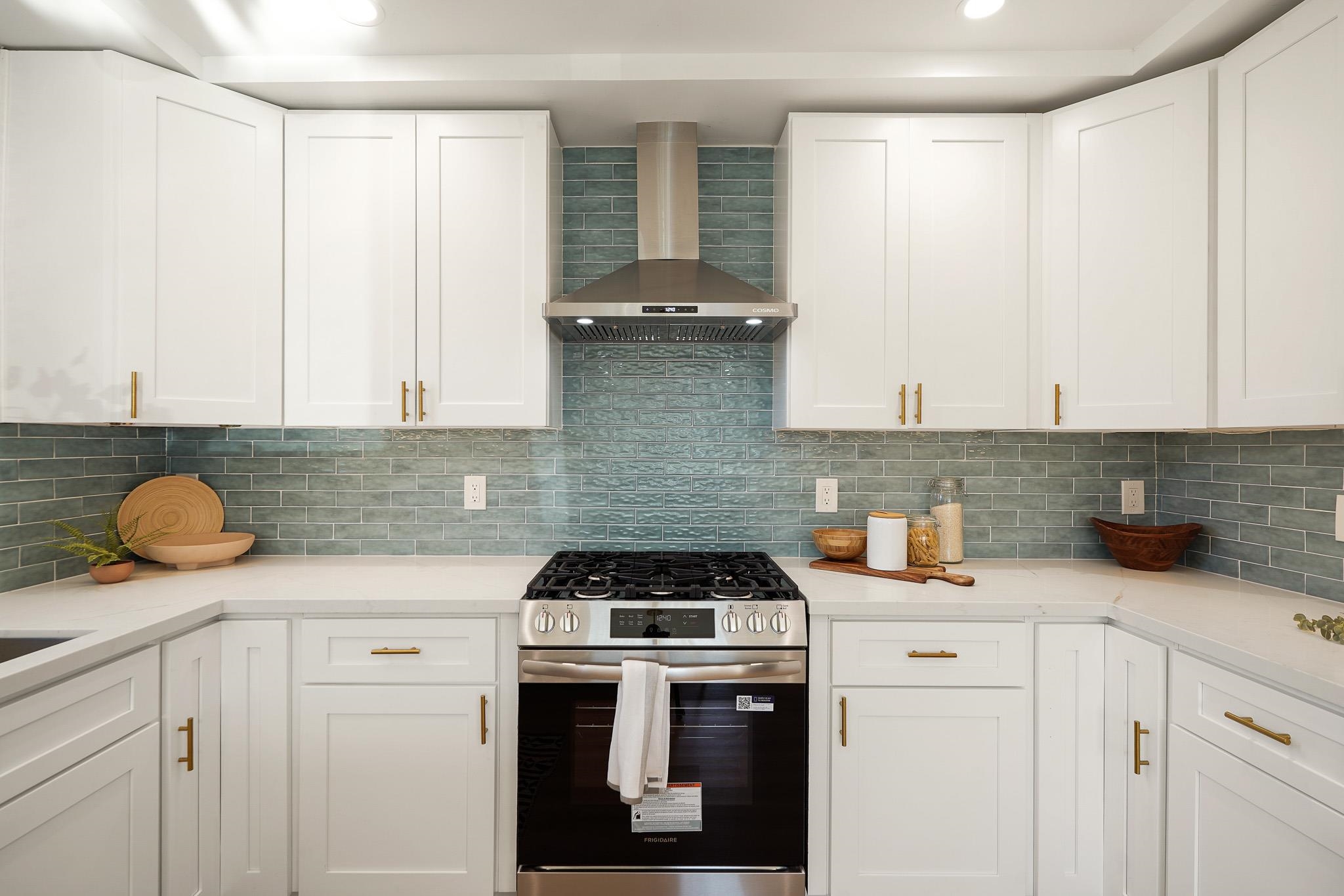 2151 Santa Rita Street Oakland, CA 94601 - Photo 12 of 46 Kitchen with stainless steel gas range oven, wall chimney exhaust hood, white cabinets, tasteful backsplash, and light stone counters
