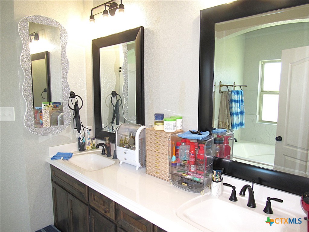 7606 Palladium Loop Killeen, TX 76542 - Photo 11 of 28 a bathroom with a sink vanity mirror and a bath tub
