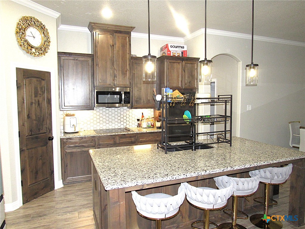 7606 Palladium Loop Killeen, TX 76542 - Photo 6 of 28 a kitchen with granite countertop kitchen island stainless steel appliances a refrigerator sink and stove