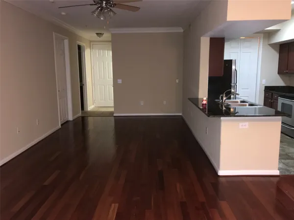 a view of a kitchen counter space with wooden floor and a ceiling fan