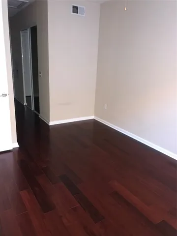 an empty room with wooden floor and closet