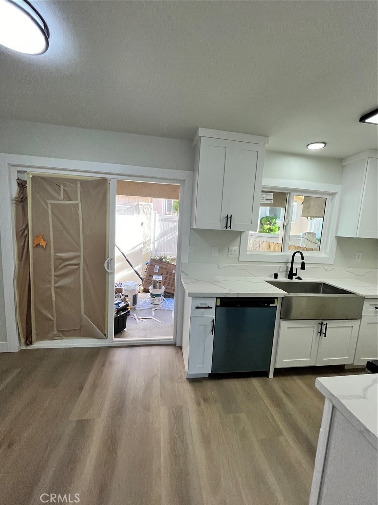 2007 Huntington Lane, Unit 2 Redondo Beach, CA 90278 - Photo 15 of 22 a open kitchen with granite countertop a stove a sink a refrigerator and white cabinets with wooden floor