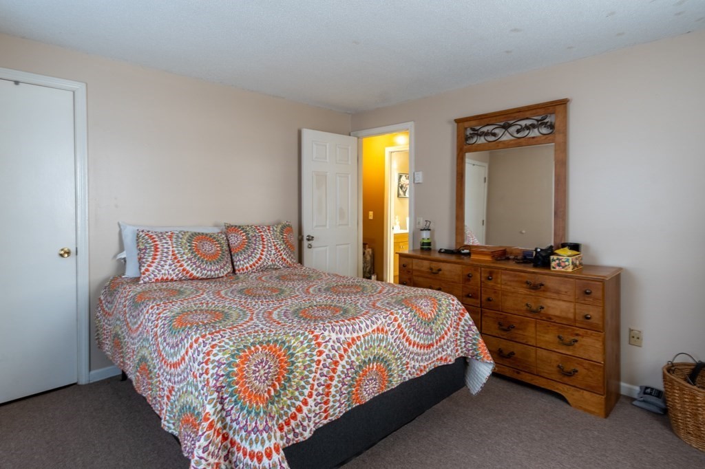 209-211 Verge Street Springfield, MA 01129 - Photo 9 of 14 a bed sitting in a bedroom next to a window and mirror