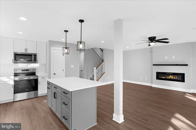 a kitchen with a stove a refrigerator and a wooden floor