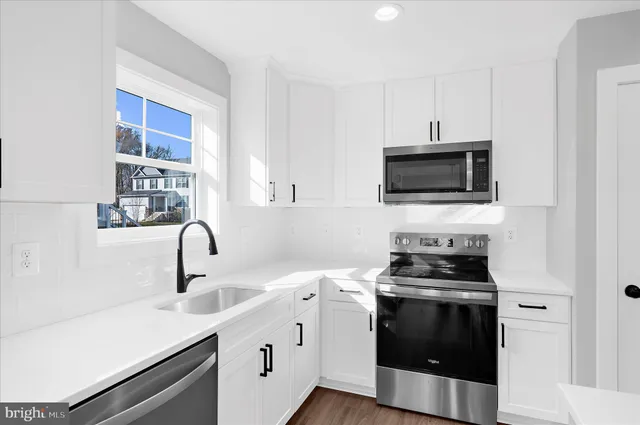 a kitchen with a sink stove and microwave