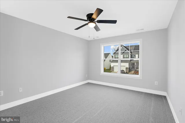 an empty room with chandelier fan