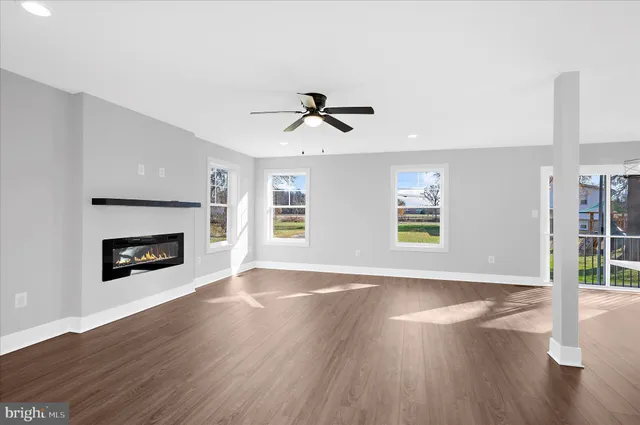 an empty room with windows and fireplace