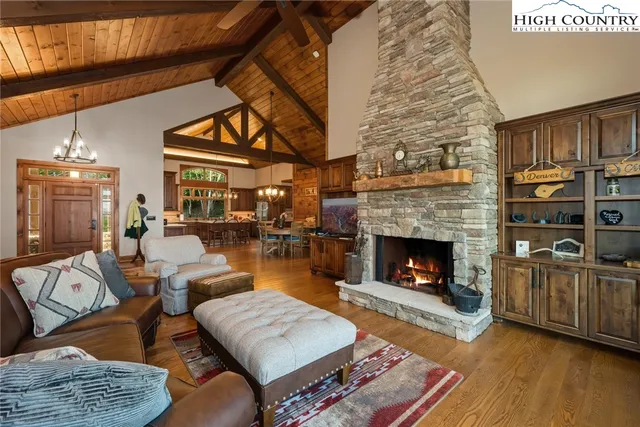 a living room with furniture a fireplace a rug and a window