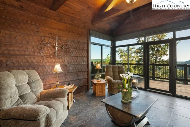 a living room with furniture and floor to ceiling windows