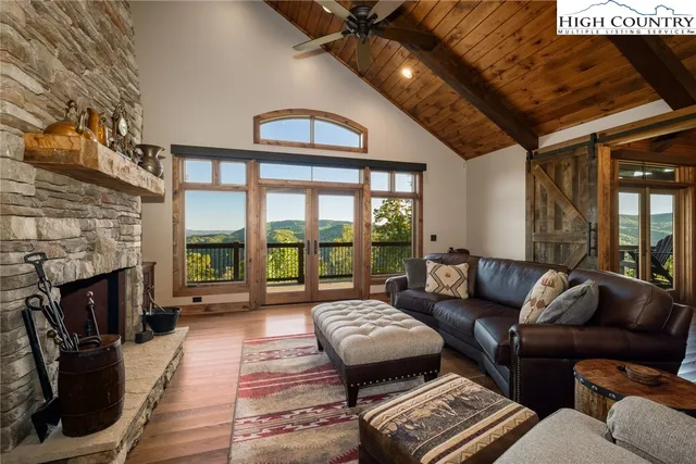 a living room with furniture a fireplace and a floor to ceiling window