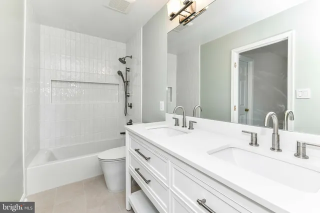 a bathroom with a bathtub shower sink vanity and toilet