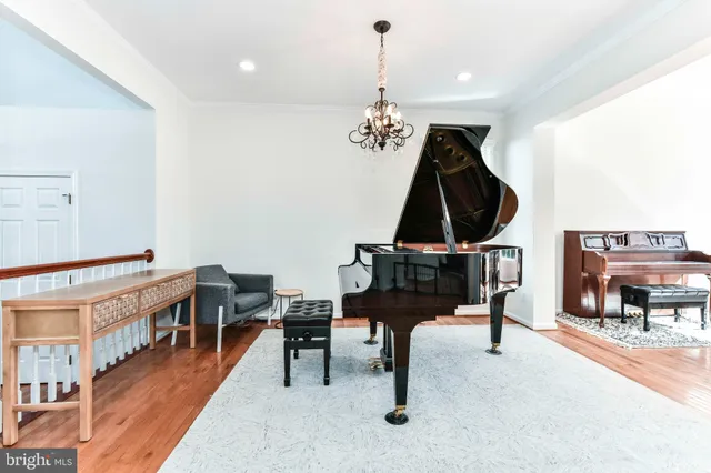 a living room with furniture a piano and a bookshelf