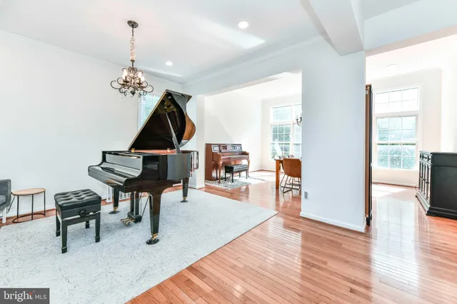 a living room with furniture a dining table and a chandelier