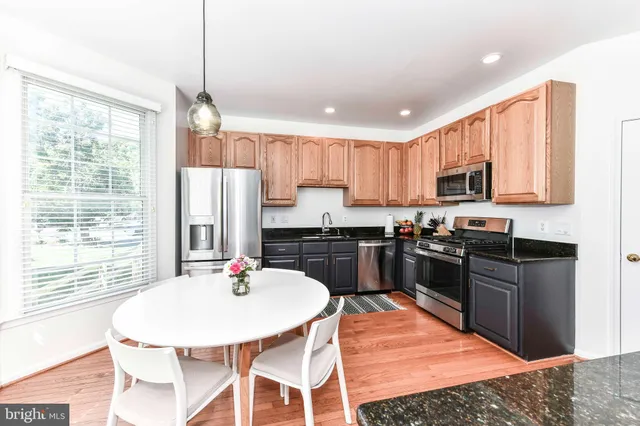 a kitchen with stainless steel appliances granite countertop a stove a kitchen island a sink a refrigerator and a granite counter tops