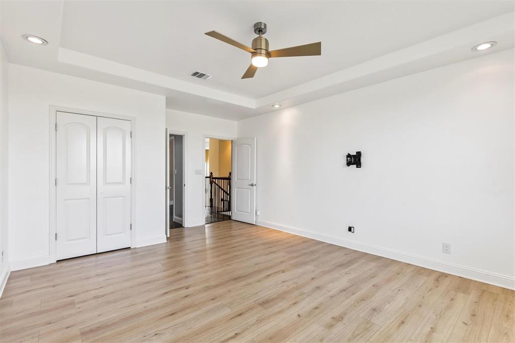 9583 Neal Road Forney, TX 75126 - Photo 17 of 34 an empty room with wooden floor and ceiling fan