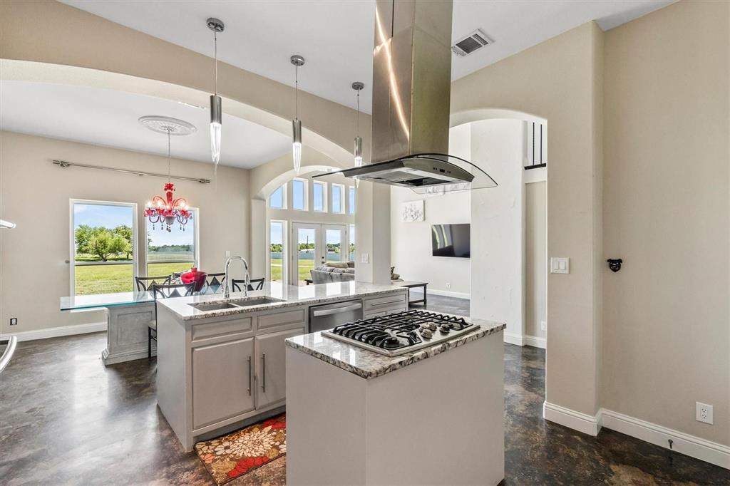 9583 Neal Road Forney, TX 75126 - Photo 9 of 34 a kitchen that has a lot of cabinets a stove and a wooden floor